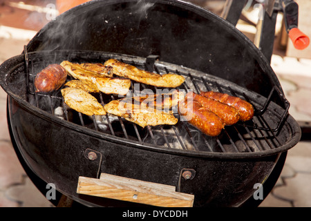 Les saucisses et la viande de poulet sur un gril. Garden party. Banque D'Images