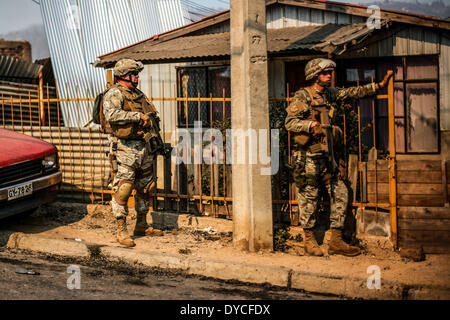 Valparaiso, Chili. 13 avr, 2014. Les feux intenses consomment une communauté sur une colline juste à l'extérieur de la ville côtière de Valparaiso. Plus de 10 000 personnes ont été évacuées en une armée de pompiers ont combattu un incendie de tueur que --À la veille-- tore de l'historique port de Valparaiso et a fait au moins 15 morts. L'incendie, qui a débuté dans les bois Samedi, vidé de 500 foyers comme flammes avancé dans la ville de 270 000, célèbre pour son centre classé au patrimoine mondial de l'UNESCO aux rues pavées et maisons en bois peint de couleurs vives. Crédit : Pablo Rojas/NurPhoto ZUMAPRESS.com/Alamy Madariaga/Live N Banque D'Images