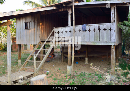 Petite ferme sur des poteaux pour attraper l'air frais avec la personne se reposant dans un hamac en dessous, village O Sra, Battambang, Cambodge, Banque D'Images