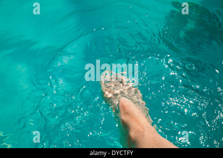 Une femme caucasienne dips son pied dans une piscine de l'hôtel. Banque D'Images