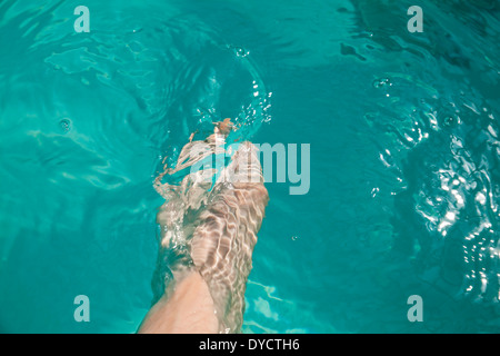 Une femme caucasienne dips son pied dans une piscine de l'hôtel. Banque D'Images