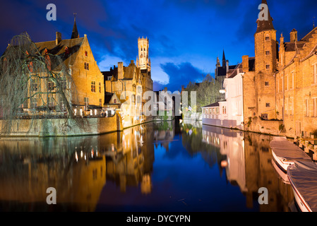 BRUGES, Belgique — les eaux calmes des canaux médiévaux de Bruges créent des reflets miroirs de l'architecture historique et de l'emblématique tour du beffroi au crépuscule. Ces canaux, datant du XIIe siècle, forment un réseau qui a valu à Bruges le surnom de « Venise du Nord ». Les bâtiments médiévaux préservés le long des voies navigables contribuent au patrimoine mondial de l'UNESCO de la ville. Banque D'Images