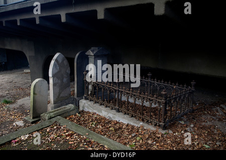 Pierres tombales 19thC sous un pont du 20ème siècle dans le cimetière de Grafton, Auckland Nouvelle Zélande. Banque D'Images