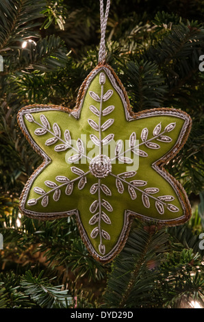 Un tissu vert star ornament est suspendu à un sapin de Noël Banque D'Images