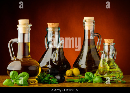 Différentes bouteilles d'huile d'olive infusée avec des herbes fraîches Banque D'Images