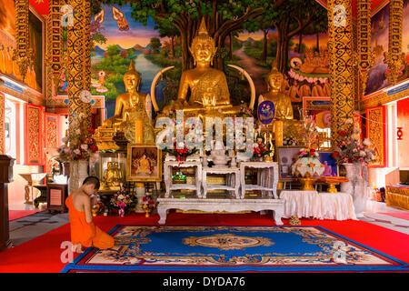 Novice, moine priant devant une statue de Bouddha de Wat Sri, Sriboonruang Boon Ruang Temple, Chiang Rai, Thaïlande du Nord Banque D'Images