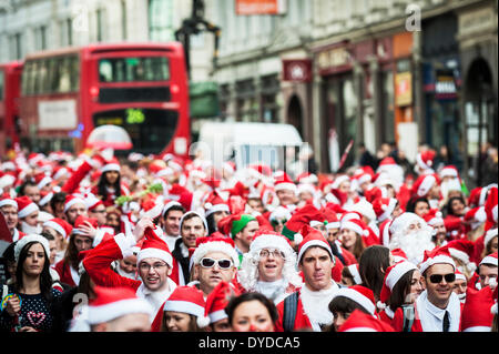 Des centaines de Santas marchant par Londres pour célébrer l'événement annuel Santacon. Banque D'Images