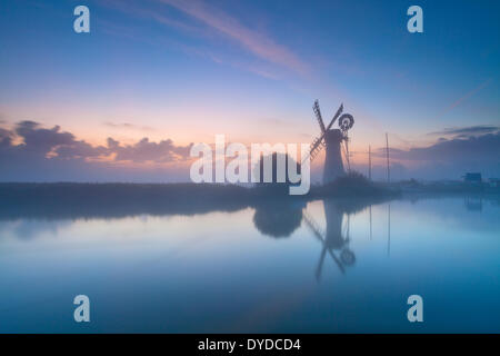 Thurne Mill au lever du soleil sur un matin brumeux sur les Norfolk Broads. Banque D'Images