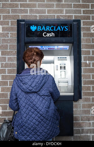 Une femme de retirer de l'argent dans un distributeur. Banque D'Images