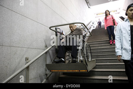 Shanghai. 14 avr, 2014. Un homme entre dans une station de métro avec l'aide d'un élévateur de fauteuil roulant dans l'est de la Chine à Shanghai, le 14 avril 2014. Une enquête auprès de la population senior 2013 présente plus d'un quart des habitants de Shanghai sont âgés de 60 ans et plus, faisant de la métropole la plus sénile, ville de Chine. © Fang Zhe/Xinhua/Alamy Live News Banque D'Images