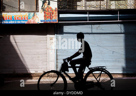 La silhouette d'un garçon sur un vélo. Banque D'Images