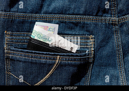 Pochette en cuir anglais montrant les billets dans la poche arrière de jeans. Banque D'Images