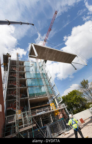 L'opérateur maintient des cordes pour levage grue guide sur un chantier de construction. Banque D'Images