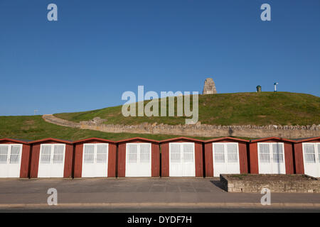 La porte dérobée blanc cabanes de plage sur la plage de Swanage en face de War Memorial sur la colline. Banque D'Images