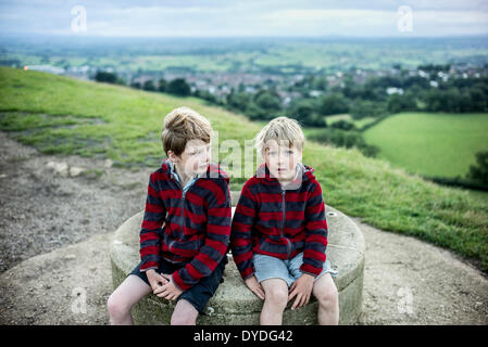 Deux garçons en haut de Tor de Glastonbury au crépuscule. Banque D'Images