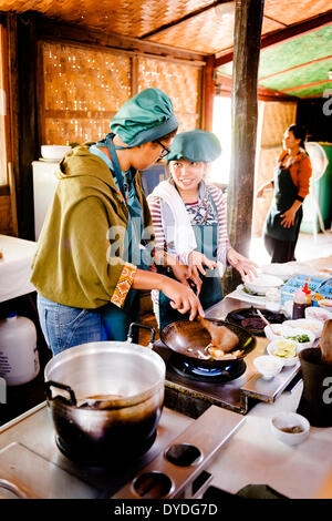 Un tuteur de mandater un élève à l'école de cuisine Tum Tum Cheng à Luang Prabang au Laos. Banque D'Images