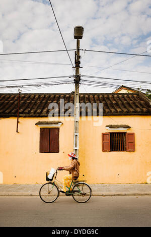 Un cycliste de passage à Hoi An. Banque D'Images