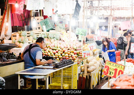 Un vendeur de fruits à la lecture du document le Mercado de la Merced à Mexico. Banque D'Images