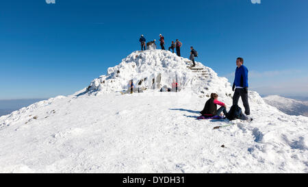 Un groupe de marcheurs se reposant par Snowdon summit dans le parc national de Snowdonia. Banque D'Images