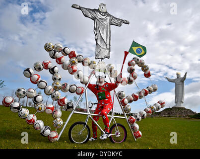 Swiebodzin, Pologne. Apr 15, 2014. Location designer Dieter 'Didi' Senft présente ses soccer vélo pour la Coupe du Monde de football au Brésil, en Pologne, de Świebodzin 15 avril 2014. Le concepteur de Brandebourg a conçu un vélo intégrant une copie de la statue du Christ Rédempteur à Rio de Janeiro et 72 ballons de soccer. Il y a une statue de Jésus en ce qui est de Świebodzin six mètres plus haut que celui sur Rio de Janeiro. Photo : PATRICK PLEUL/DPA/Alamy Live News Banque D'Images