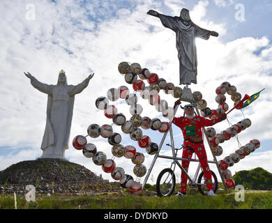 Swiebodzin, Pologne. Apr 15, 2014. Location designer Dieter 'Didi' Senft présente ses soccer vélo pour la Coupe du Monde de football au Brésil, en Pologne, de Świebodzin 15 avril 2014. Le concepteur de Brandebourg a conçu un vélo intégrant une copie de la statue du Christ Rédempteur à Rio de Janeiro et 72 ballons de soccer. Il y a une statue de Jésus en ce qui est de Świebodzin six mètres plus haut que celui de Rio de Janeiro. Photo : PATRICK PLEUL/DPA/Alamy Live News Banque D'Images