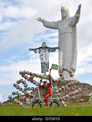 Swiebodzin, Pologne. Apr 15, 2014. Location designer Dieter 'Didi' Senft présente ses soccer vélo pour la Coupe du Monde de football au Brésil, en Pologne, de Świebodzin 15 avril 2014. Le concepteur de Brandebourg a conçu un vélo intégrant une copie de la statue du Christ Rédempteur à Rio de Janeiro et 72 ballons de soccer. Il y a une statue de Jésus en ce qui est de Świebodzin six mètres plus haut que celui de Rio de Janeiro. Photo : PATRICK PLEUL/DPA/Alamy Live News Banque D'Images