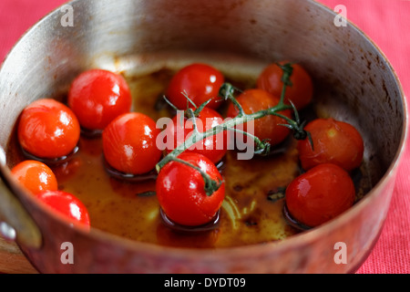 Tomates cerises cuites sur la vigne Banque D'Images