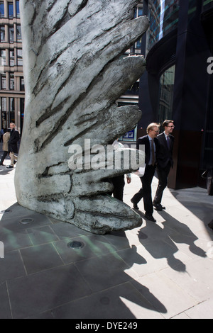 Les travailleurs de la ville par le passage de l'oeuvre d'un géant de l'aile de bronze lors d'un midi de printemps dans le quartier financier de Londres. Comme la lumière se reflète sur les immeubles de bureaux à proximité, la foule à l'heure du déjeuner devant ce géant des illustrations sur leur façon de réunions et sandwicheries. Les dix mètres de haut est la sculpture en bronze par le président de la Royal Academy of Arts, Christopher Le Brun, commandé par Hammerson en 2009. Elle est appelée 'La Ville' de l'aile et a été jeté par Morris Singer, fondateurs de l'art réputé pour être la plus ancienne fonderie d'art dans le monde. Banque D'Images