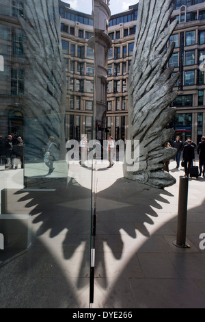 Les travailleurs de la ville par le passage de l'oeuvre d'un géant de l'aile de bronze lors d'un midi de printemps dans le quartier financier de Londres. Comme la lumière se reflète sur les immeubles de bureaux à proximité, la foule à l'heure du déjeuner devant ce géant des illustrations sur leur façon de réunions et sandwicheries. Les dix mètres de haut est la sculpture en bronze par le président de la Royal Academy of Arts, Christopher Le Brun, commandé par Hammerson en 2009. Elle est appelée 'La Ville' de l'aile et a été jeté par Morris Singer, fondateurs de l'art réputé pour être la plus ancienne fonderie d'art dans le monde. Banque D'Images