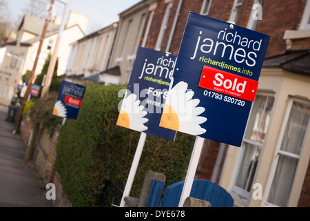 Le marketing pour vendre les panneaux de l'agent immobilier local Richard James à l'extérieur des maisons sur une rue de Swindon Wiltshire, UK Banque D'Images