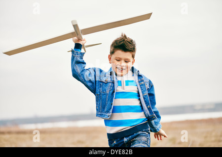 Photo de happy kid Playing with toy airplane en dehors Banque D'Images