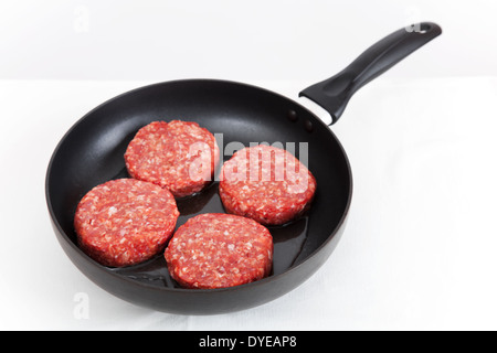 Quatre boulettes rouge réside dans une casserole noire Banque D'Images