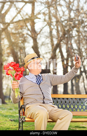 Personnes âgées holding tulipes et en tenant l'extérieur selfies Banque D'Images