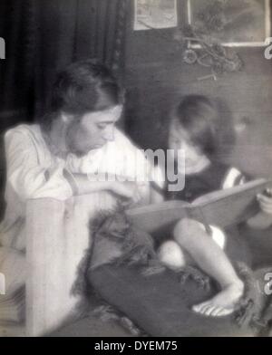 Béatrice Baxter Ruyl en blanc, avec Ruth Ruyl en short sur la table, la lecture livre. photo de F. Hollande 24, 1864-1933, photographe. 1909 tirage photographique : Platinum. Banque D'Images