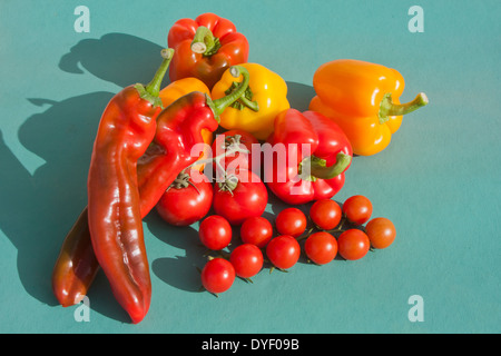 Tomates cerises Poivrons et piments sur fond vert Banque D'Images