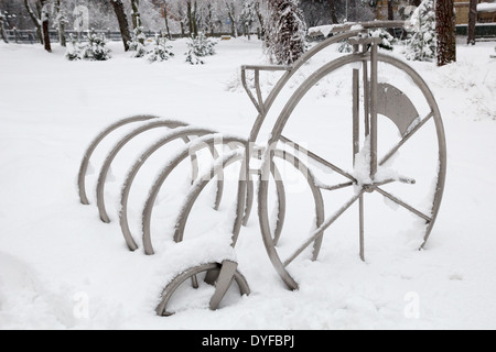 La neige dans le parc de la ville. Support vélo couvert de neige. Banque D'Images