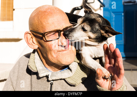 Un chien lèche le nez de son propriétaire dans Portobello Road, Londres, UK Banque D'Images