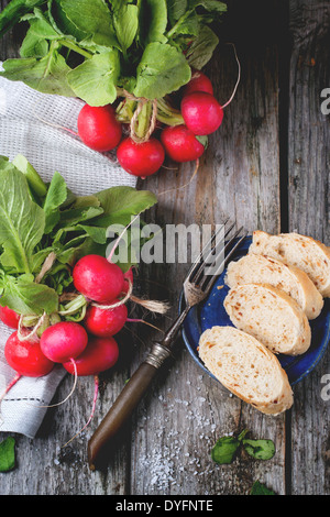 Humide frais radis à fourche vintage, sel de mer et du pain sur la table en bois. Vue d'en haut Banque D'Images