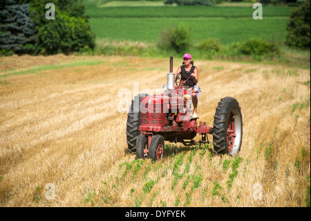 Driving vieille agricultrice le tracteur dans le champ, Banque D'Images