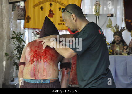MANDALUYONG, PHILIPPINES - AVRIL 17 : Un homme découpe une petite plaie sur un dos d'un pénitents dans un rituel expiant leurs péchés durant la célébration de Jeudi Saint Jeudi Saint ou à Mandaluyong City, à l'est de Manille, Philippines, le 17 avril. (Photo de Jay Ganzon/Pacific Press) Banque D'Images
