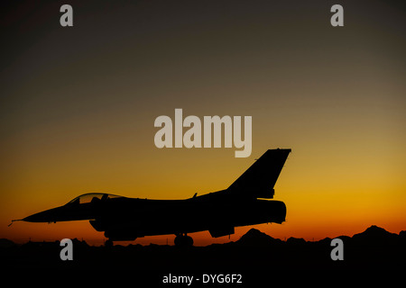 L'US Air Force F-16C Fighting Falcon est assis sur la rampe de stationnement des aéronefs au coucher du soleil le 13 avril 2014 à la base aérienne Davis-Monthan Air Force Base, en Arizona. Banque D'Images