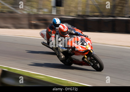 2 cavaliers pour moto racing par lodges coin à Oulton Park Race circuit. Banque D'Images