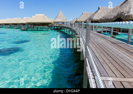 Promenade promenade menant à plus de luxueux bungalows sur pilotis dans un lieu de villégiature des récifs coralliens en Polynésie Francaise Banque D'Images