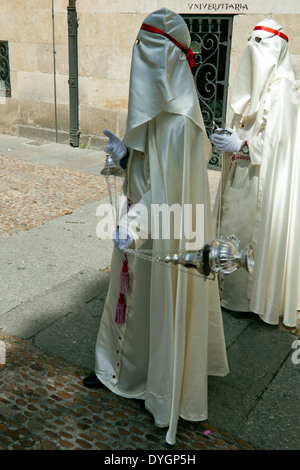 Des hommes habillés en robe blanche et le capot d'un diffuseur d'encens dans la procession des Rameaux pendant la Semana Santa, Salamanca, Espagne. Banque D'Images