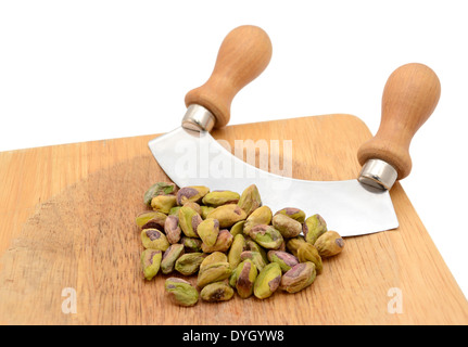 Ensemble de pistaches avec un couteau à bascule sur une planche à découper en bois Banque D'Images