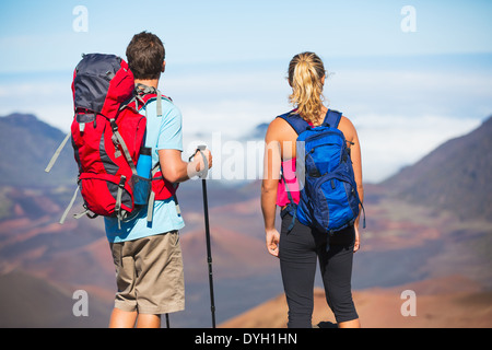 Deux randonneurs se détendre appréciant la vue imprenable depuis le sommet de la montagne. Donnant sur le cratère du volcan. Banque D'Images