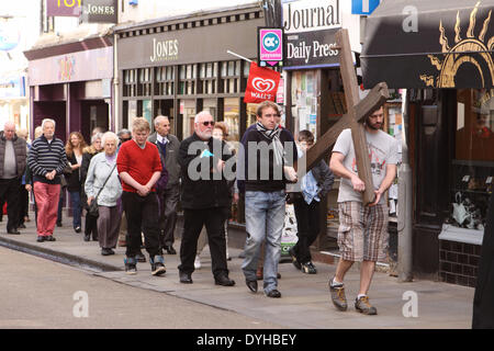 Wells, Somerset, Royaume-Uni. 18 avril, 2014. - Vendredi Saint Pâques chrétiens suivent la marche du témoin comme une croix en bois est réalisée dans les rues de l'Angleterre de la plus petite ville de la cathédrale pour célébrer la crucifixion du Christ le Vendredi saint 18 avril 2014. Banque D'Images