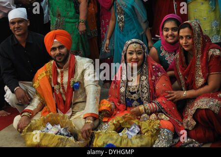 Manille, Philippines. 18 avr, 2014. Manille, Philippines - La famille et les amis posent avec les mariés pour une photo au cours de la principale aux cérémonies d'un mariage Sikh Khalsa Diwan à l'intérieur du temple Sikh indiens à Manille, coïncidant avec l'église catholique, la célébration du Vendredi Saint le 18 avril 2014. Le temple a été fondé en 1929, ce qui en fait le plus vieux temple sikh à majorité dans ce pays Catholique. © George Calvelo/NurPhoto ZUMAPRESS.com/Alamy/Live News Banque D'Images