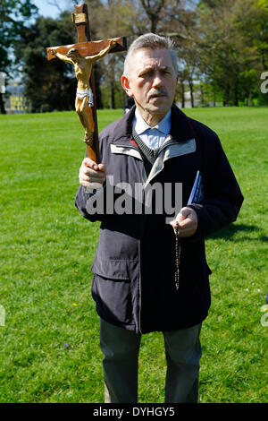 Dublin, Irlande. 18 avril 2014. Un pèlerin est vu portant un crucifix. L'archevêque de Dublin, Diarmuid Martin, a conduit plusieurs centaines de pèlerins dans un "Chemin de Croix" procession dans le parc Phoenix. Les stations avec des lectures, des chants et la méditation devrait nous rappeler de la passion et de la crucifixion de Jésus Christ. Crédit : Michael Debets/Alamy Live News Banque D'Images