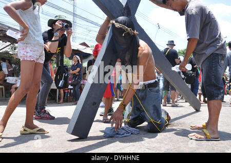 ANGELES, Pampanga, PHILIPPINES - le 18 avril : Un photographe de prendre une photo d'un pénitent à capuchon portant une croix en bois au cours de la célébration du Vendredi Saint à Pampanga le 18 avril. (Photo de Jay Ganzon/Pacific Press) Credit : PACIFIC PRESS/Alamy Live News Banque D'Images